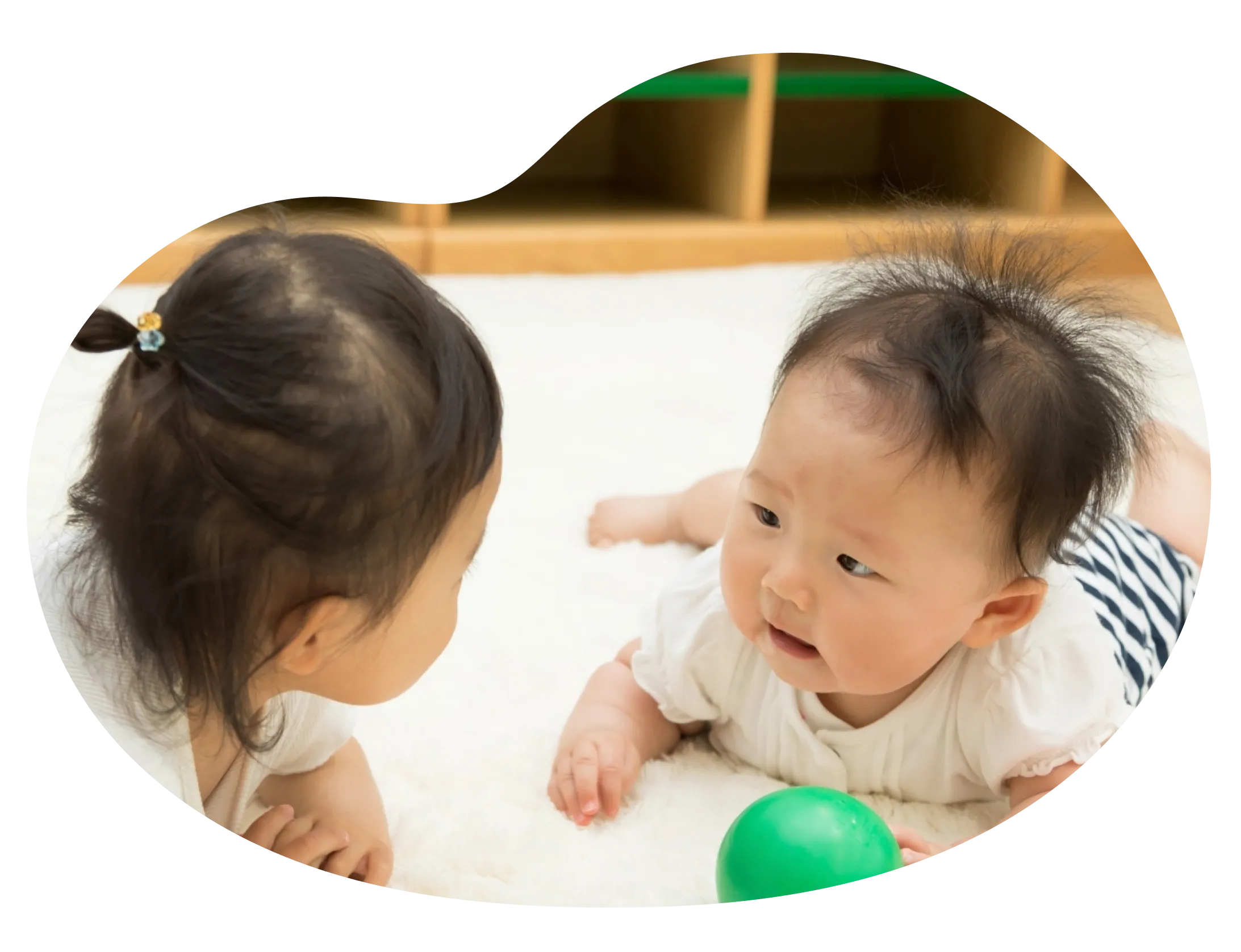 赤ちゃんと子どもがお互いを見つめ合う写真